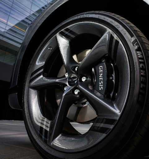 Close-up of a Genesis vehicle wheel and brake components.