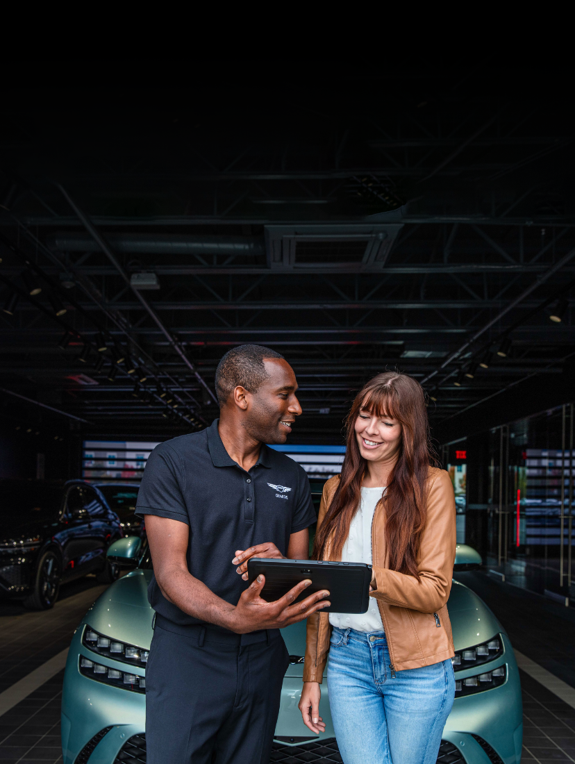 Genesis concierge assisting a customer in a showroom.