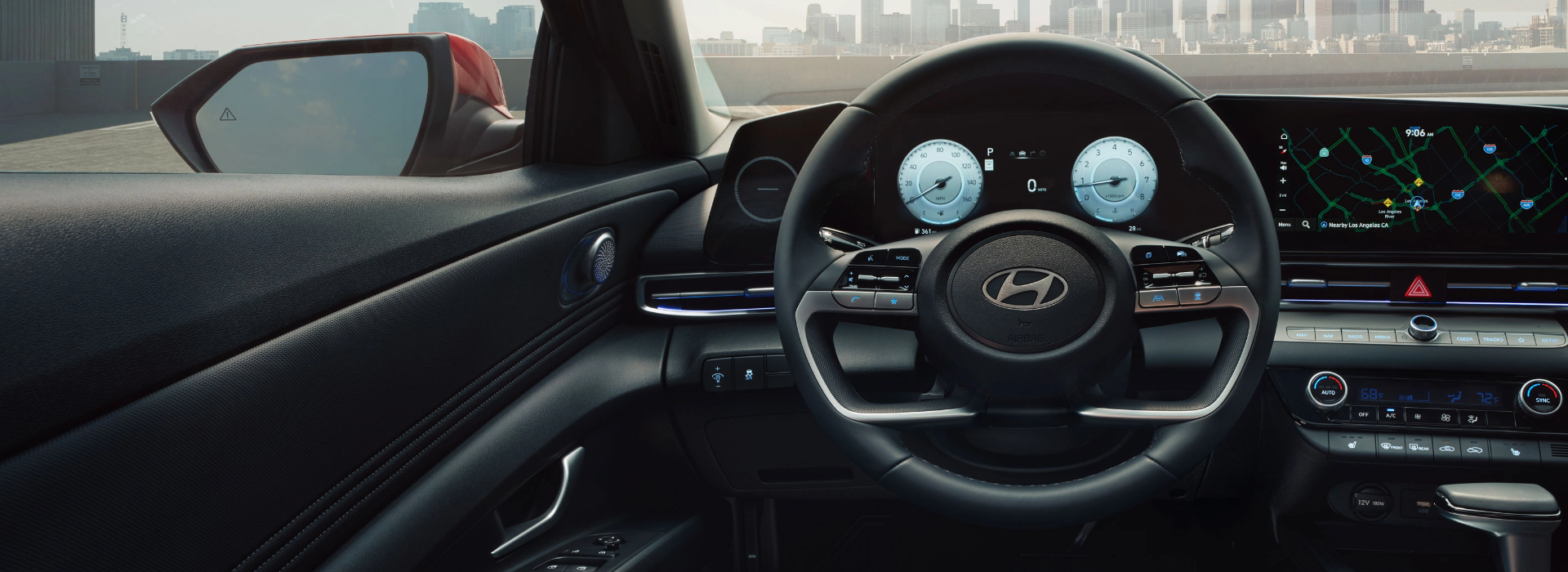 Driver’s view of Hyundai dashboard and steering wheel with digital instrument cluster and navigation display.