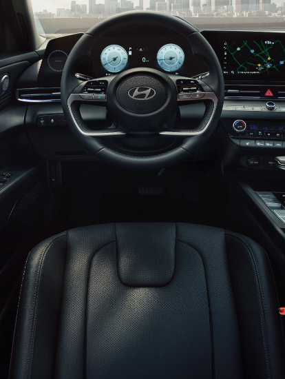 Driver’s view of Hyundai dashboard and steering wheel with digital instrument cluster and navigation display.