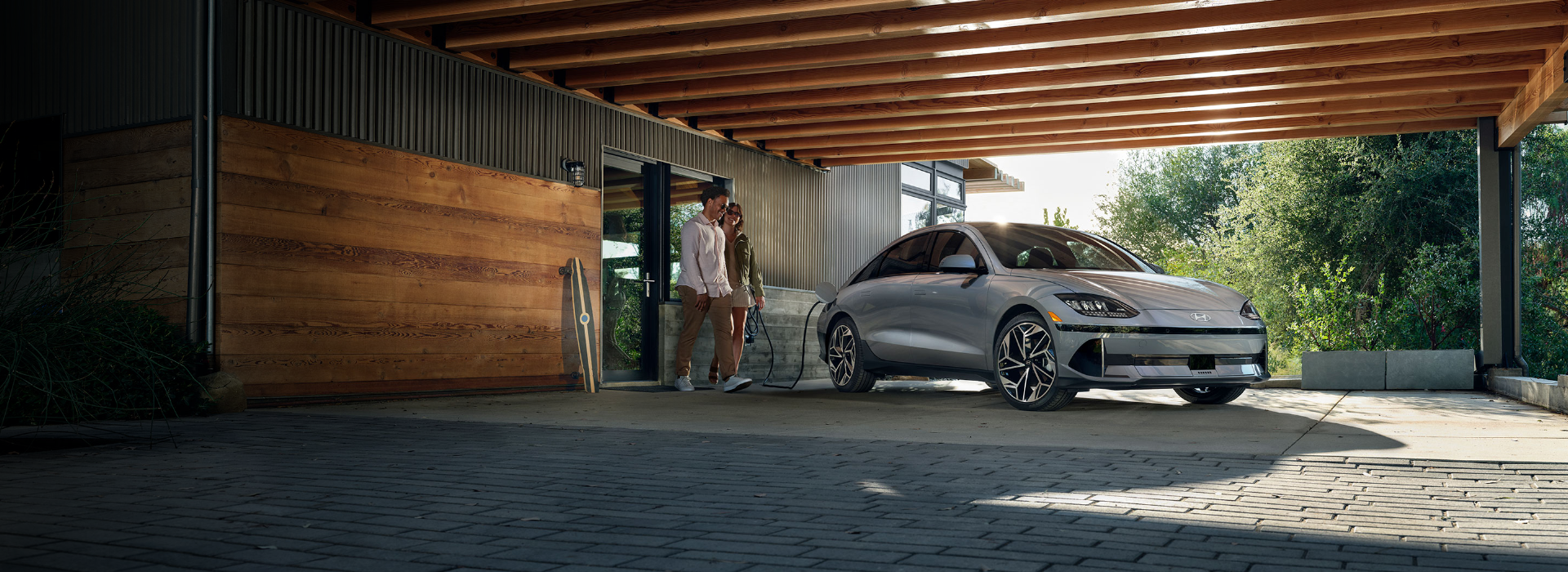 Couple walking near a Hyundai EV charging at home