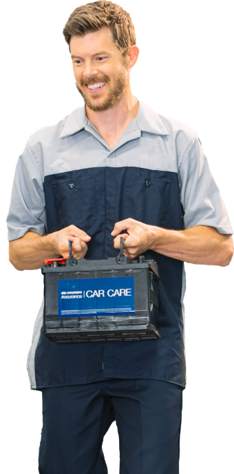 Service technician carrying Hyundai Assurance Car Care battery