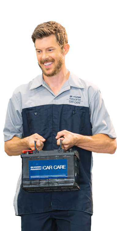 Service technician carrying Hyundai Assurance Car Care battery