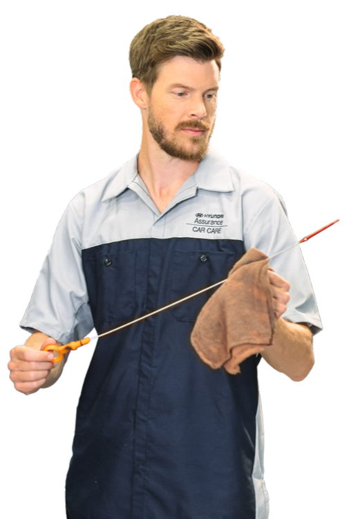 Hyundai technician checking oil level with dipstick and cloth in hand