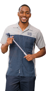 Hyundai service technician smiling and holding a tire pressure gauge tool.