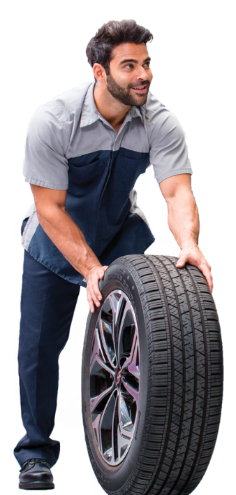 Smiling Hyundai technician in uniform rolling a tire during service