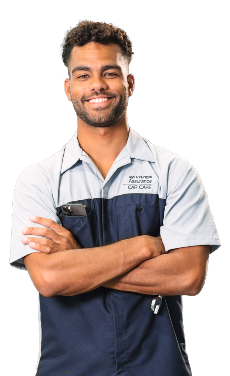 Smiling Hyundai technician in uniform, with arms crossed, standing confidently.