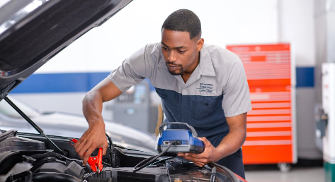 Hyundai technician testing a vehicle battery with diagnostic equipment