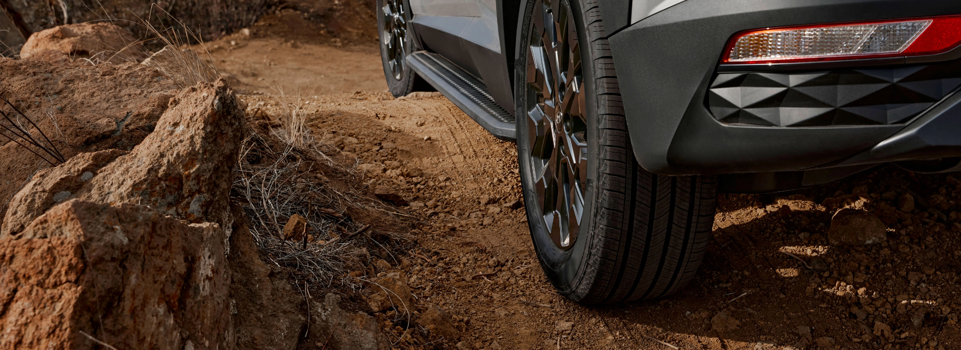 Hyundai SUV driving on rugged terrain with focus on rear tire