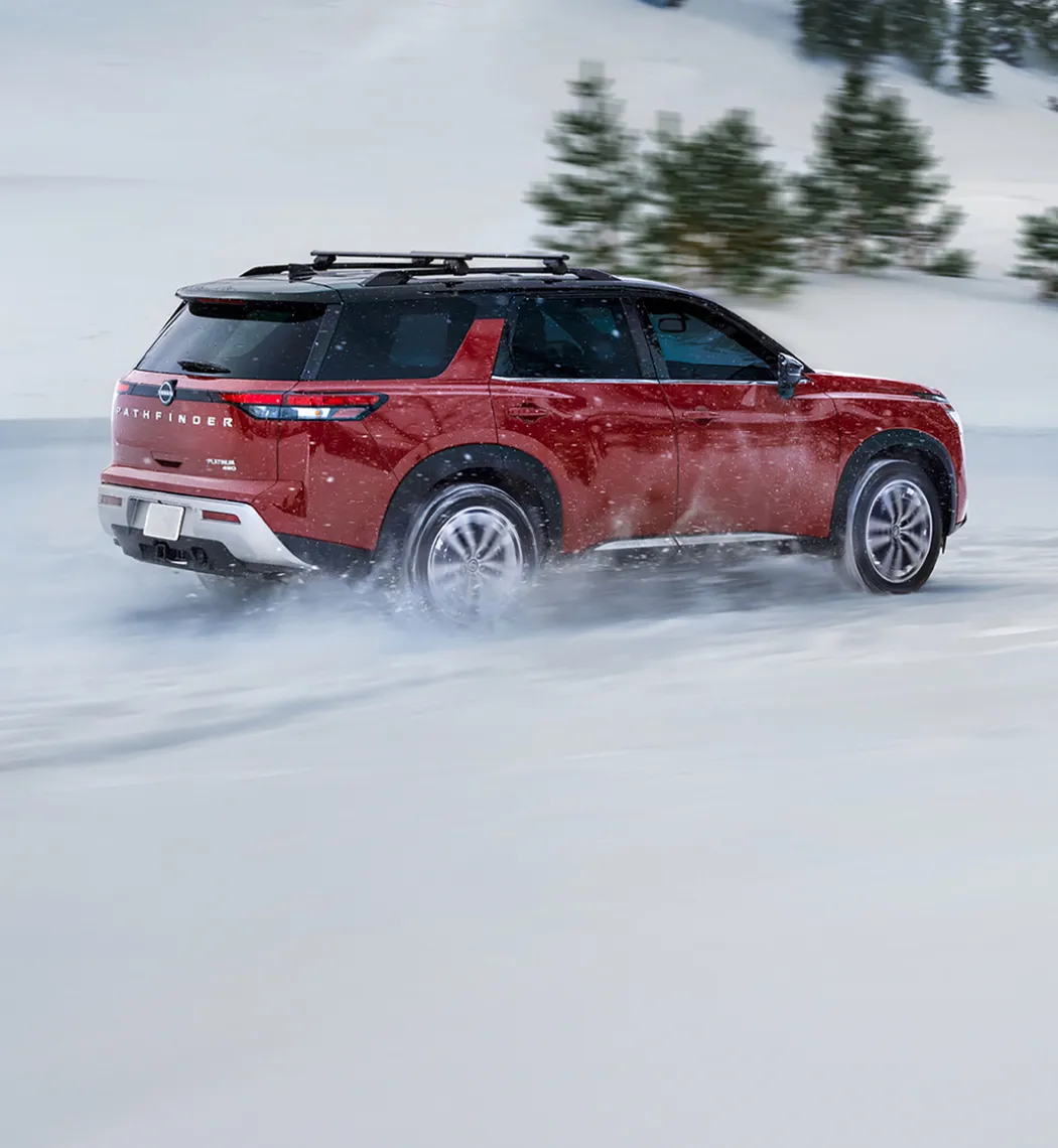 Nissan SUV traveling on snow and icy road conditions.
