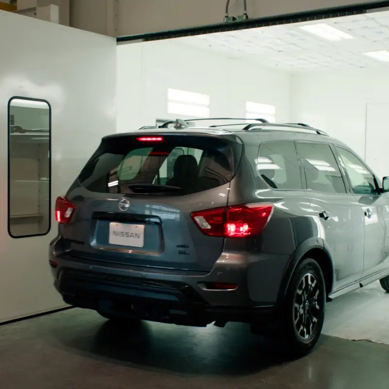 A Nissan SUV driving into a service facility.