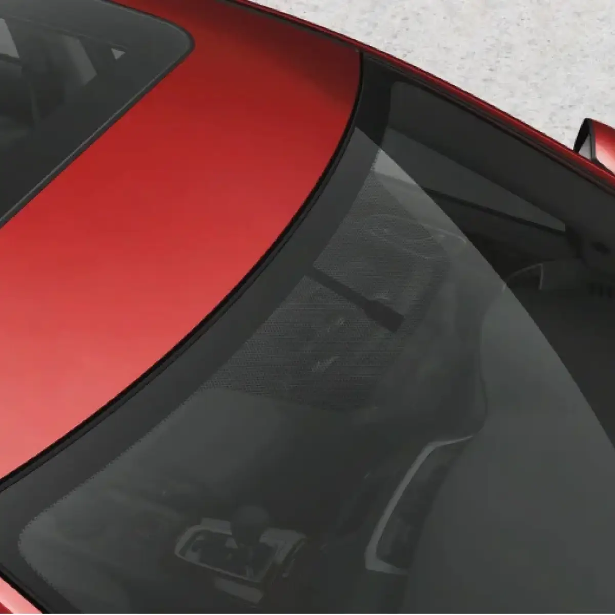 Close-up view of a red car's rear window and sunroof.