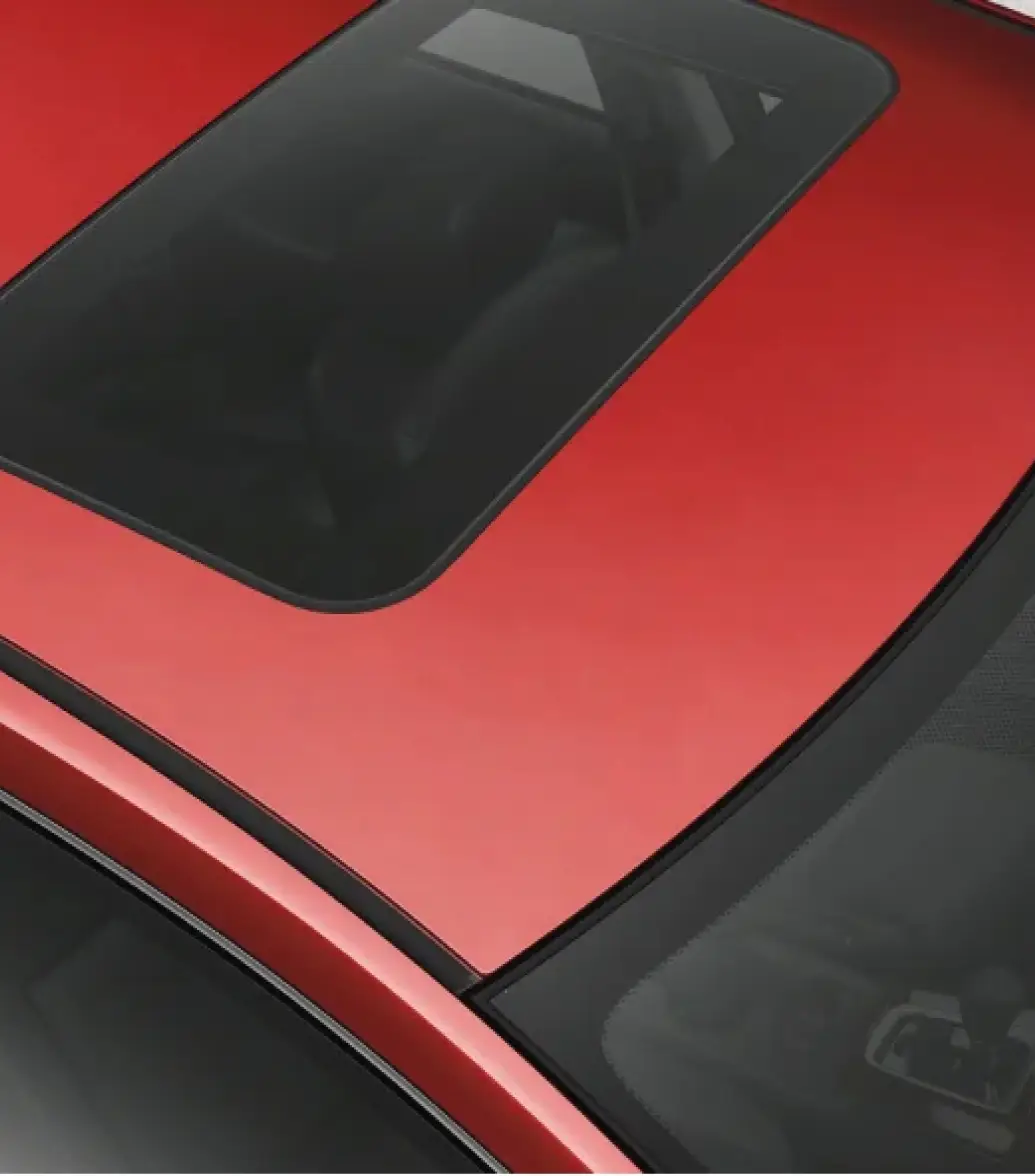 Close-up view of a red car's rear window and sunroof.