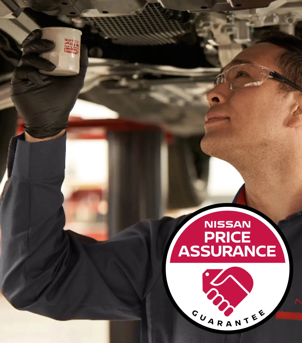 Nissan Price Assurance logo with Nissan-trained technician installing oil filter on to a lifted car in garage