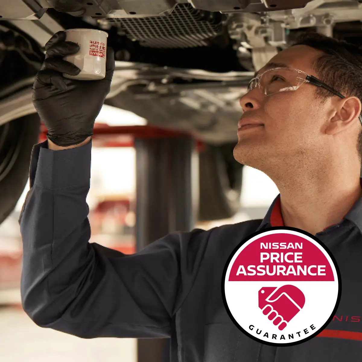 Nissan Price Assurance logo with Nissan-trained technician installing oil filter on to a lifted car in garage