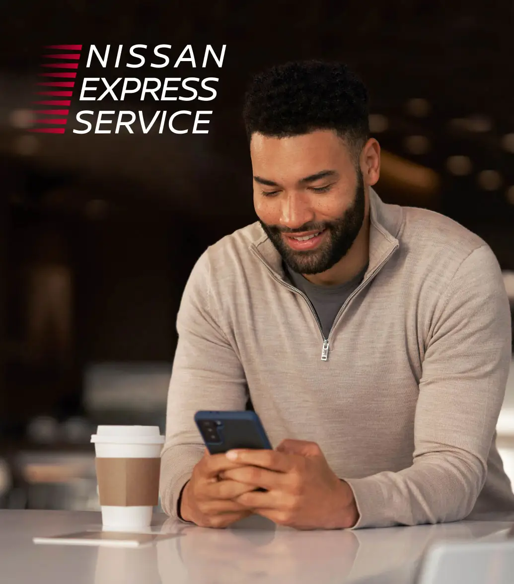 Customer happily exploring Nissan amenities on his mobile phone
